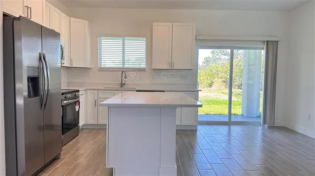 a kitchen with a window a sink and a refrigerator