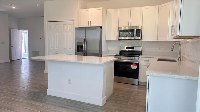 a kitchen with granite countertop a refrigerator and a stove