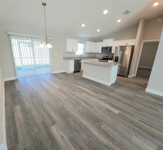 a view of kitchen with granite countertop cabinets and wooden floor