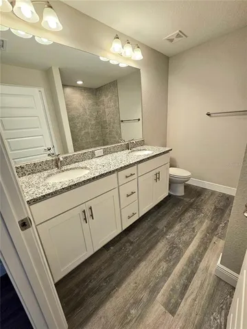 a spacious bathroom with a granite countertop sink and a mirror