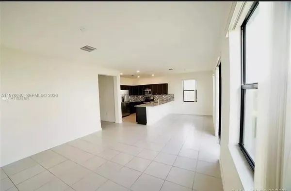 a view of a kitchen with an entryway and an empty room