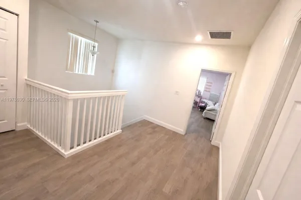 a view of a room with wooden floor and windows