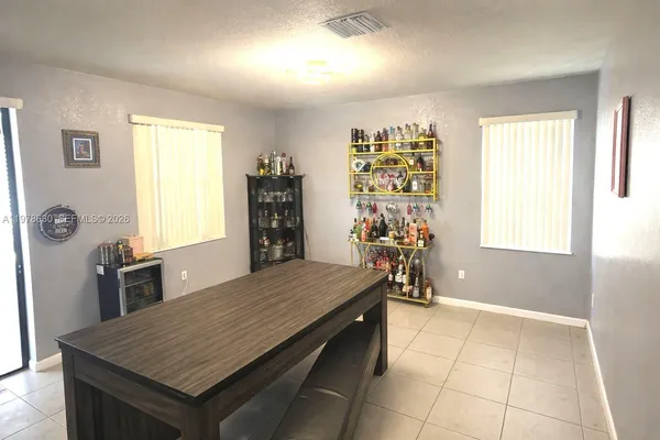 a room with a table chairs and wooden floor