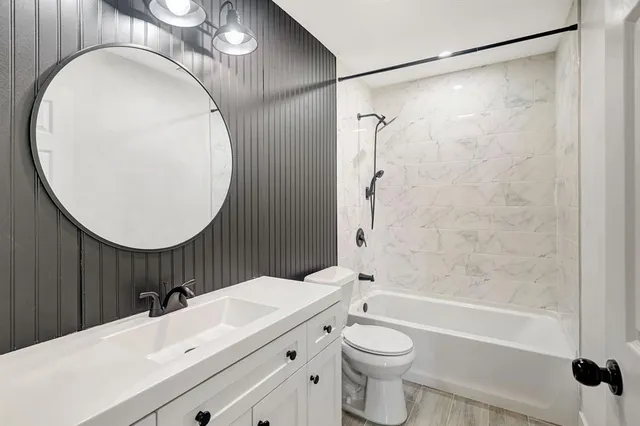 a bathroom with a sink a toilet and a mirror