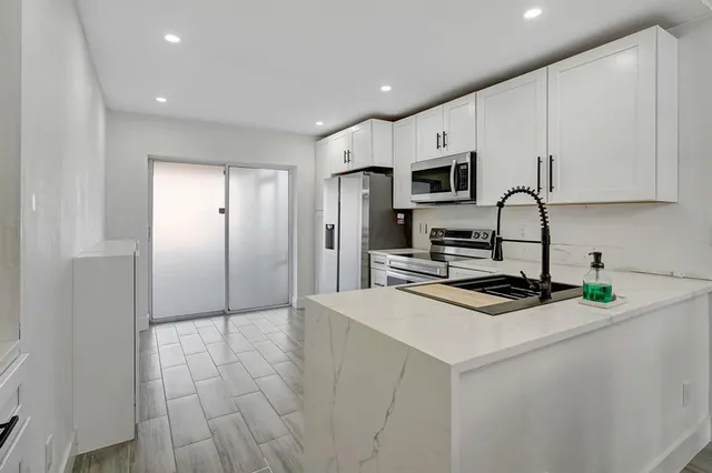 a kitchen with stainless steel appliances a refrigerator stove microwave and cabinets