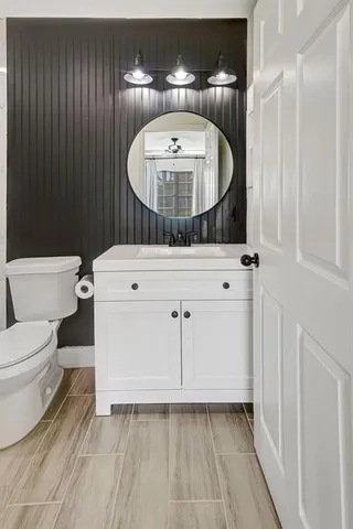 a bathroom with a sink a toilet and a mirror
