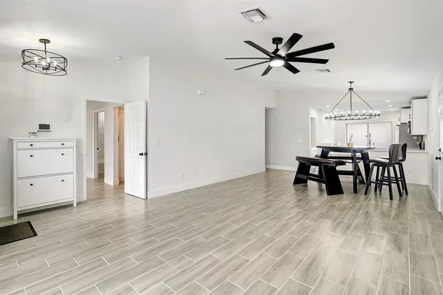 a view of a livingroom with furniture and chandelier fan