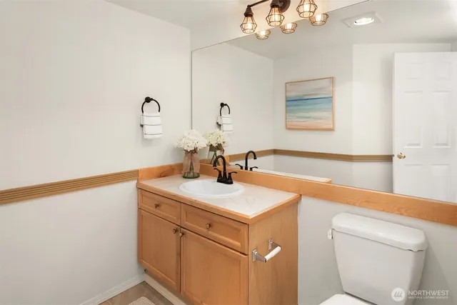 a bathroom with a sink a toilet and a mirror