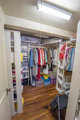 a view of walk in closet with clothes and shoes