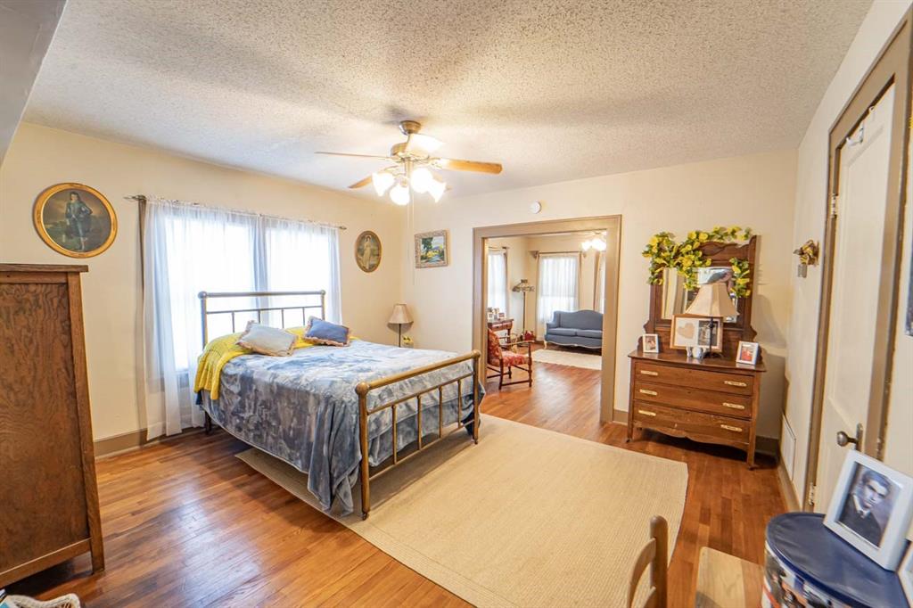 900 West Walker Street Breckenridge, TX 76424 - Photo 15 of 40 a spacious bedroom with a bed and a chandelier