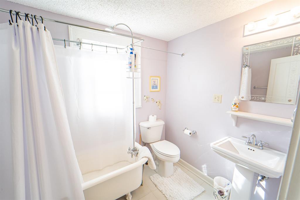 900 West Walker Street Breckenridge, TX 76424 - Photo 19 of 40 a bathroom with a sink toilet and shower