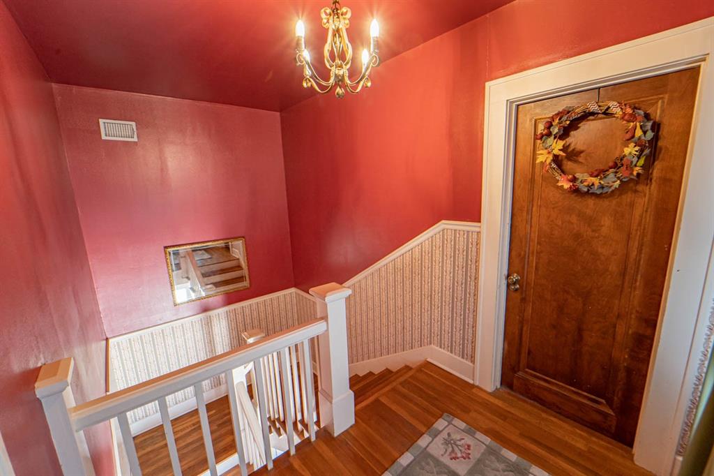 900 West Walker Street Breckenridge, TX 76424 - Photo 23 of 40 a view of a hallway with wooden floor and stairs