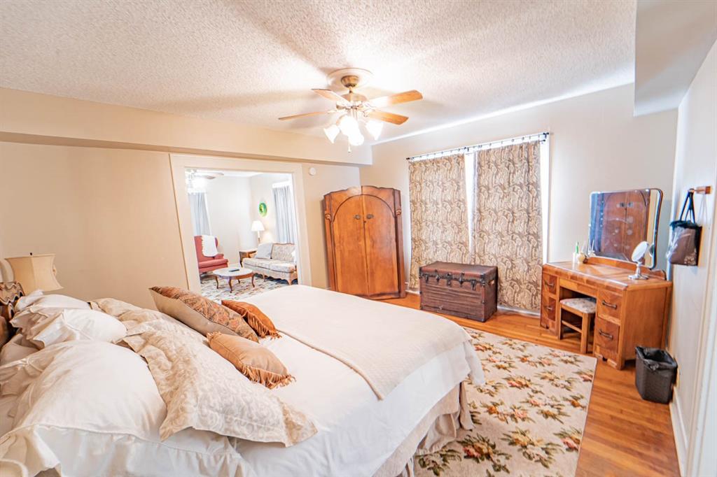 900 West Walker Street Breckenridge, TX 76424 - Photo 26 of 40 a bedroom with a bed and wooden floor