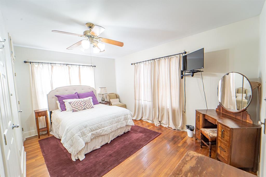 900 West Walker Street Breckenridge, TX 76424 - Photo 30 of 40 a bedroom with a bed a mirror and a window