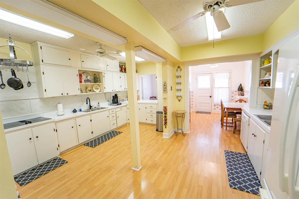 900 West Walker Street Breckenridge, TX 76424 - Photo 32 of 40 a large white kitchen with wooden floor and a sink
