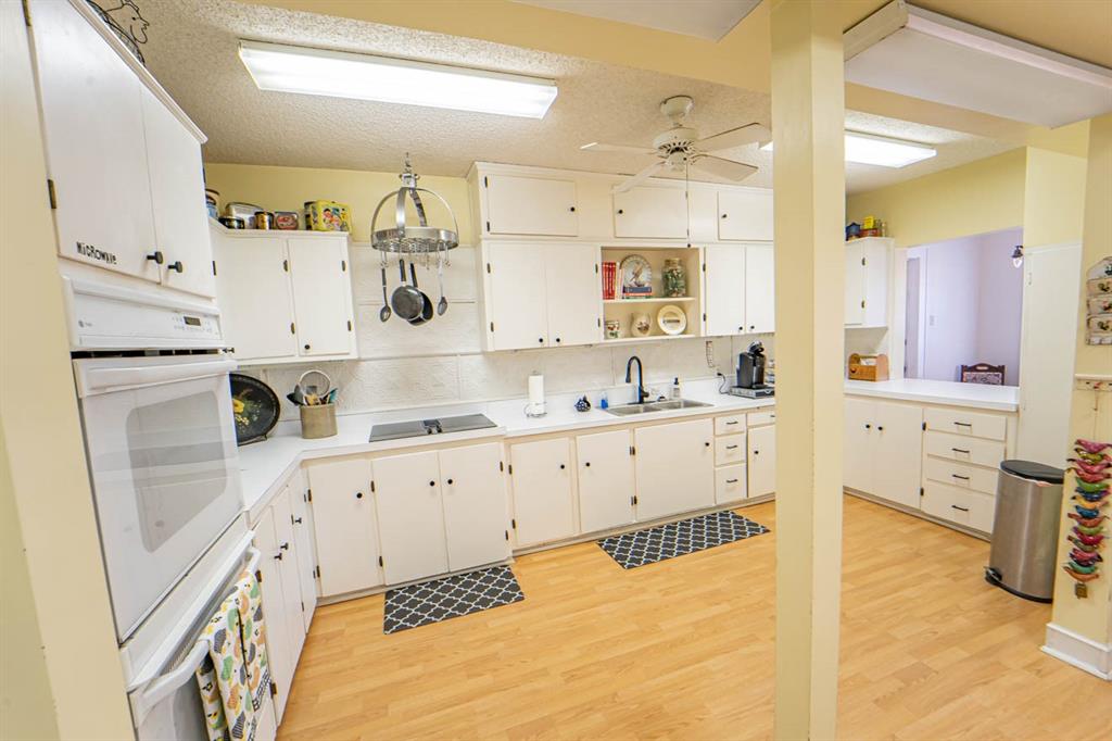 900 West Walker Street Breckenridge, TX 76424 - Photo 33 of 40 a large white kitchen with cabinets