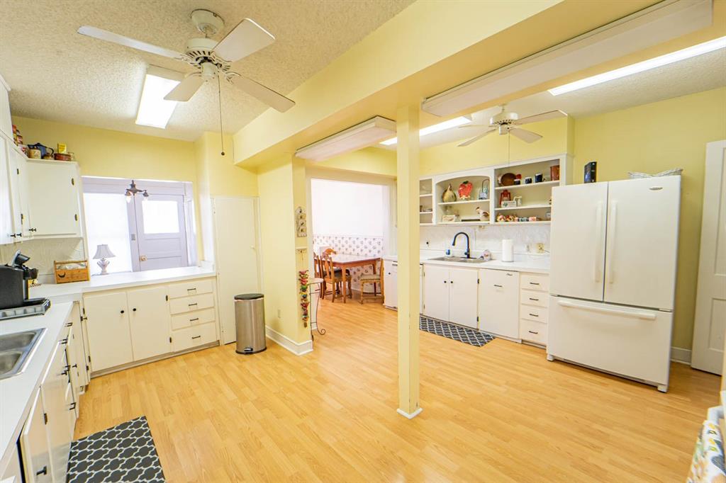 900 West Walker Street Breckenridge, TX 76424 - Photo 34 of 40 a kitchen with a refrigerator a sink dishwasher stove and white cabinets