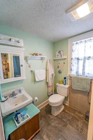a bathroom with a sink toilet and window