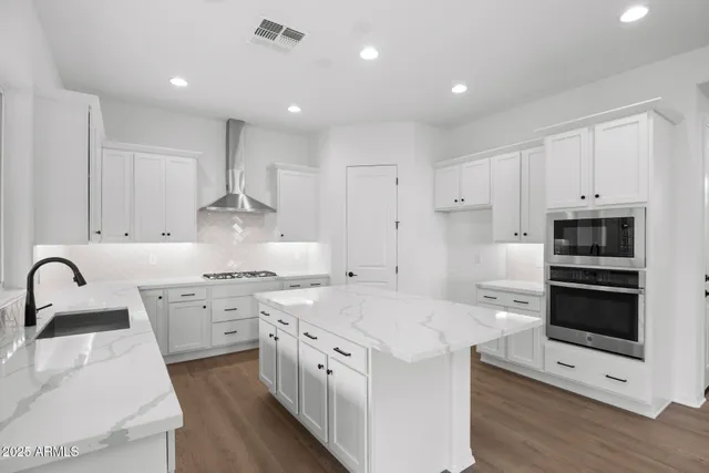a kitchen that has a lot of cabinets in it and wooden floor