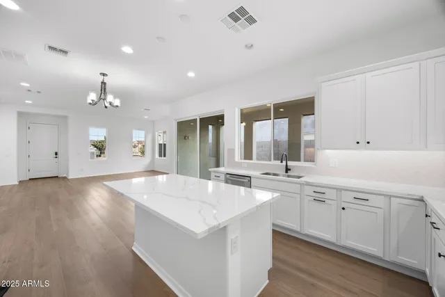 a large kitchen with kitchen island a sink stainless steel appliances and cabinets