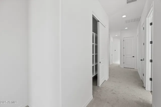 a view of a hallway with closet and wooden floor