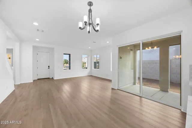 a view of a hallway with wooden floor and a chandelier