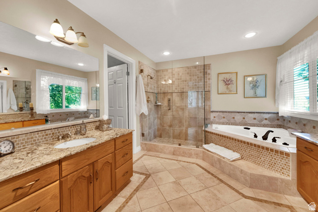 7740 Keswick Road Sandy, UT 84093 - Photo 33 of 74 Bathroom featuring a glass-enclosed shower, a corner built-in soaking tub with tiled surround, a vanity with a granite countertop, and tile flooring with a decorative border