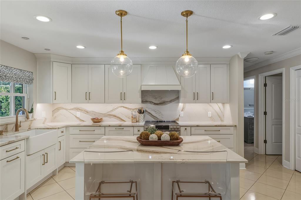 5475 Saddlebrook Way Wesley Chapel, FL 33543 - Photo 5 of 29 a kitchen with kitchen island white cabinets stainless steel appliances and wooden floor