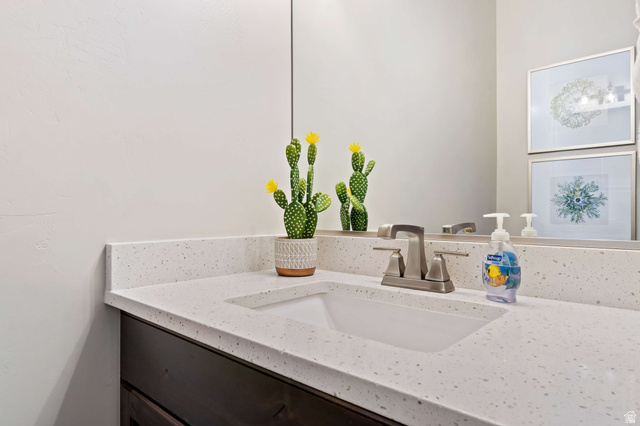 2600 Ocotillo Way, Unit 31 Santa Clara, UT 84765 - Photo 32 of 73 Vanity with an integrated rectangular sink, light speckled countertop, dark wood-finish cabinetry, and a brushed nickel faucet
