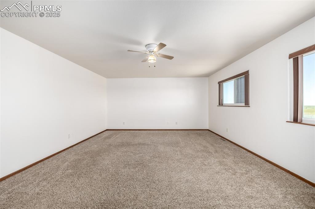 6065 Mulberry Road Calhan, CO 80808 - Photo 15 of 45 Spare room featuring ceiling fan, light colored carpet, and healthy amount of natural light