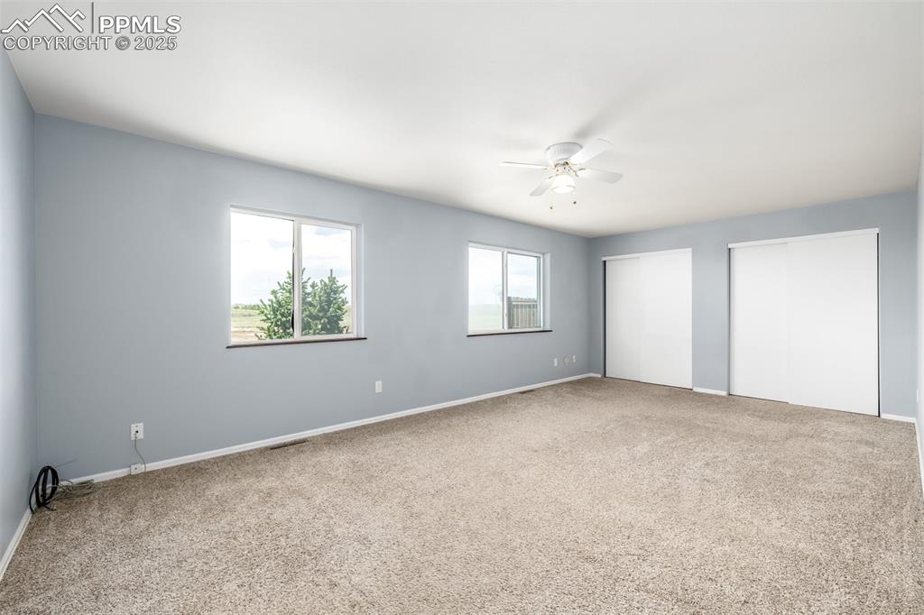 6065 Mulberry Road Calhan, CO 80808 - Photo 19 of 45 Unfurnished bedroom with two closets, carpet, and a ceiling fan