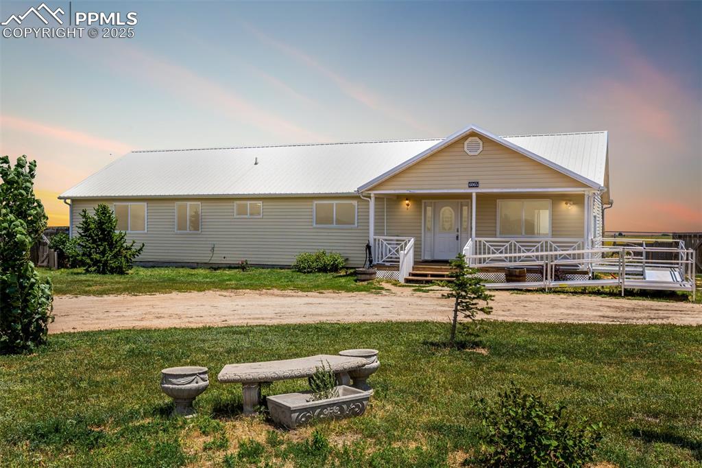 6065 Mulberry Road Calhan, CO 80808 - Photo 2 of 45 View of front of property with a front yard, covered porch, and a metal roof