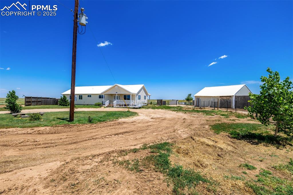 6065 Mulberry Road Calhan, CO 80808 - Photo 3 of 45 View of yard featuring a pole building, an outbuilding, and covered porch