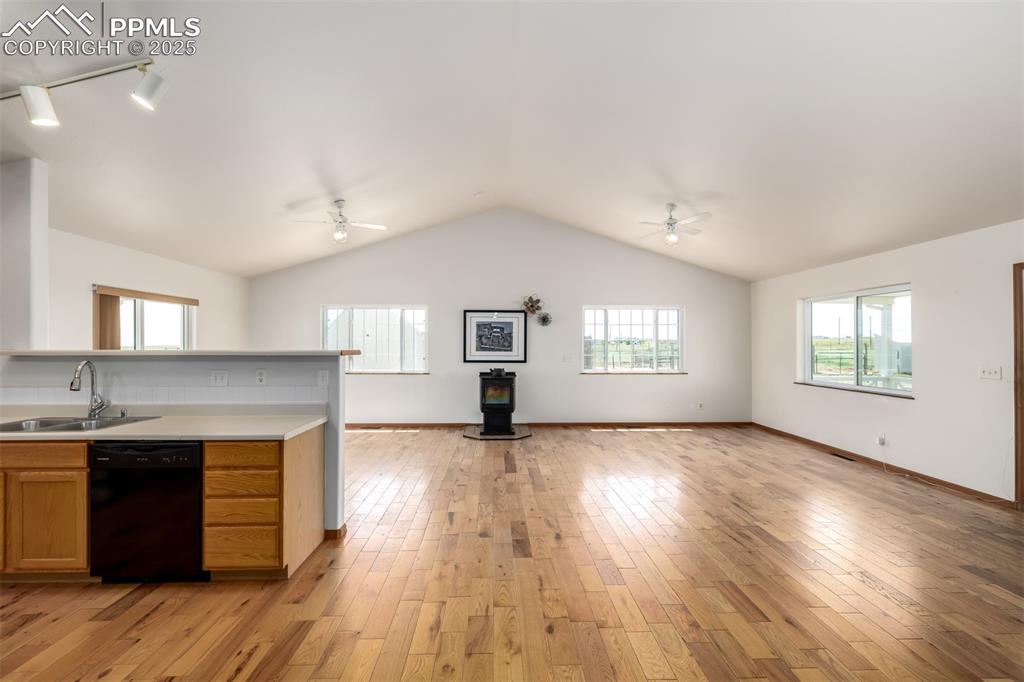 6065 Mulberry Road Calhan, CO 80808 - Photo 8 of 45 Kitchen with dishwasher, ceiling fan, open floor plan, a wood stove, and vaulted ceiling