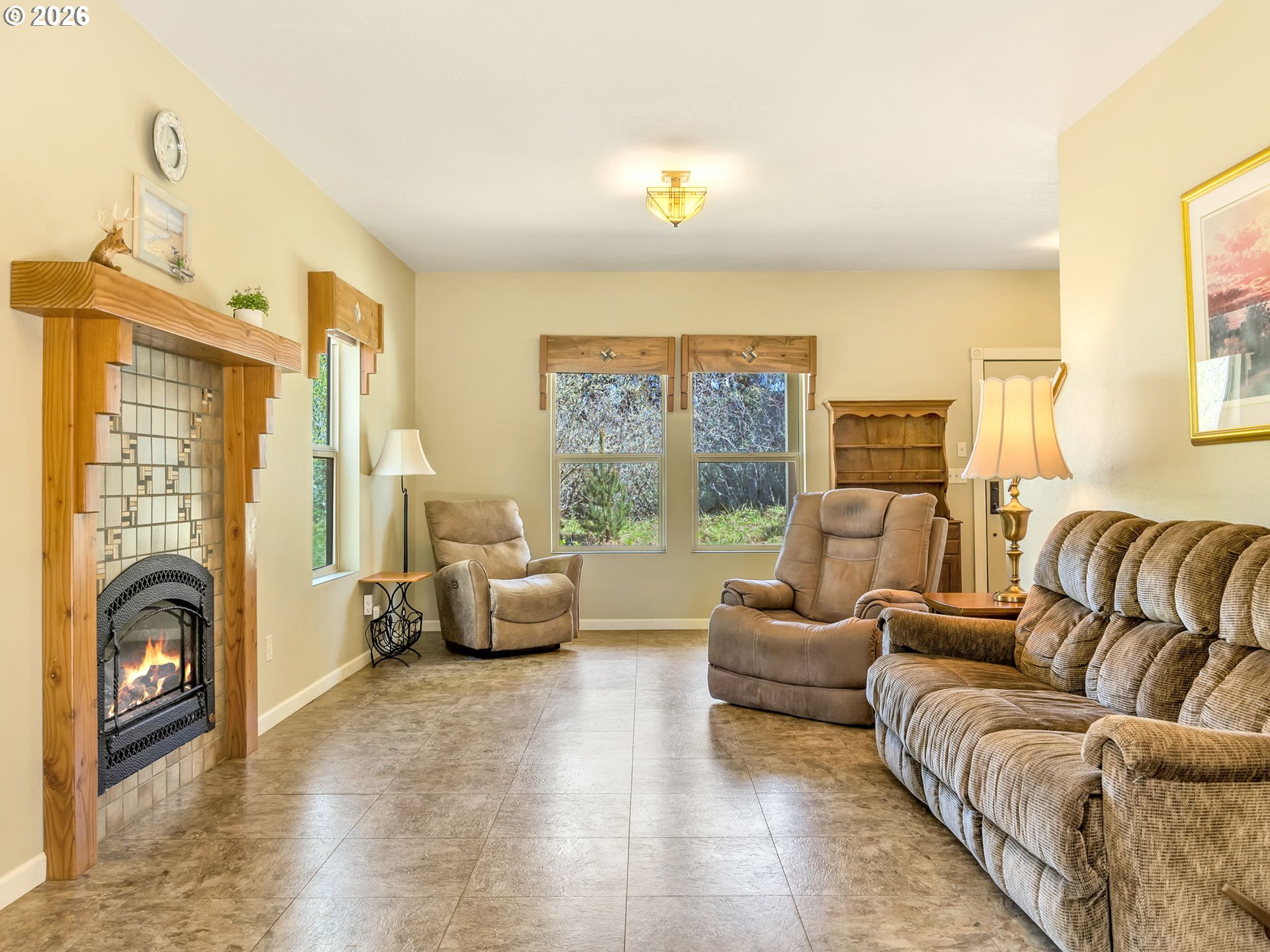 1077 Southwest Ridge Road Warrenton, OR 97146 - Photo 5 of 46 a living room with furniture two large windows next to a fireplace