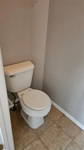 a white toilet sitting next to a white cabinet