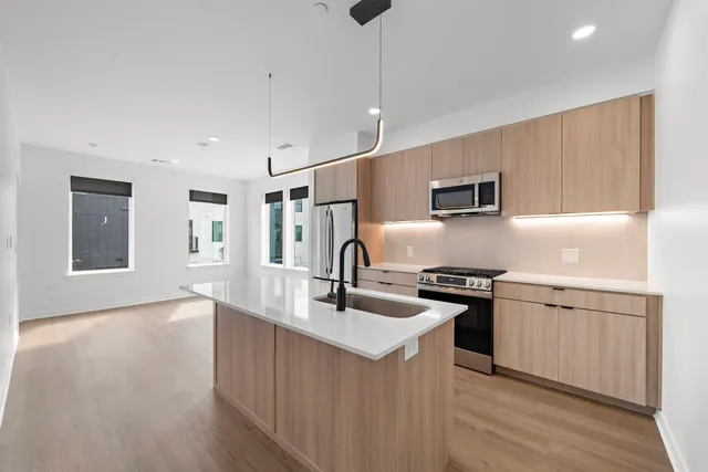 a kitchen with stainless steel appliances granite countertop a sink stove and refrigerator
