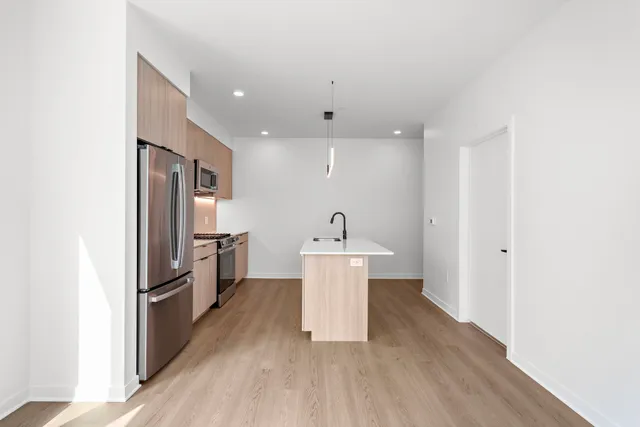 a kitchen with stainless steel appliances a refrigerator and a stove top oven