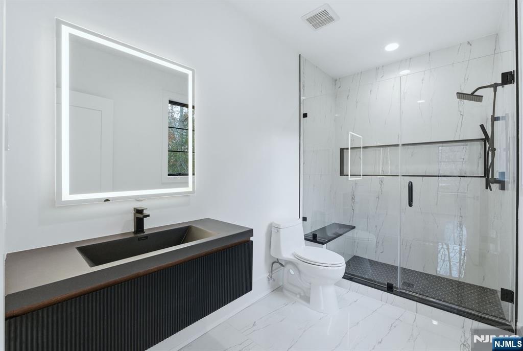 12 Irene Court Demarest, NJ 07627 - Photo 28 of 49 a bathroom with a sink toilet a mirror and shower