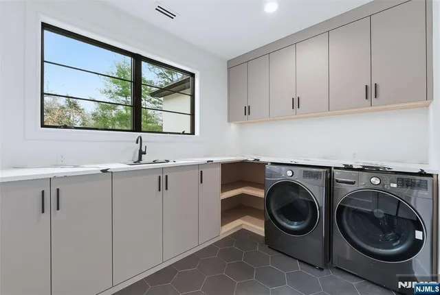 a utility room with sink dryer and washer
