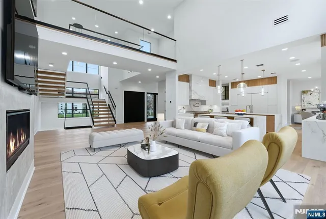 a living room with furniture kitchen view and a wooden floor