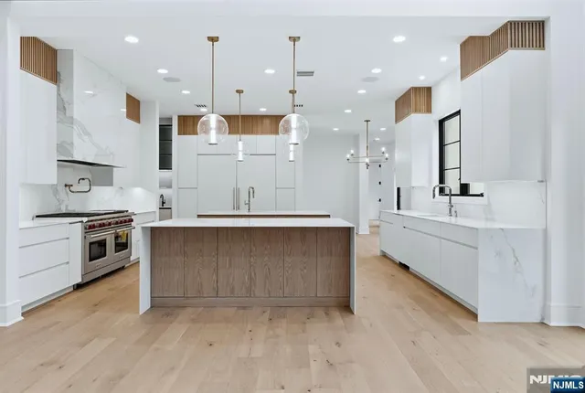 a view of kitchen with kitchen island a sink stainless steel appliances and cabinets