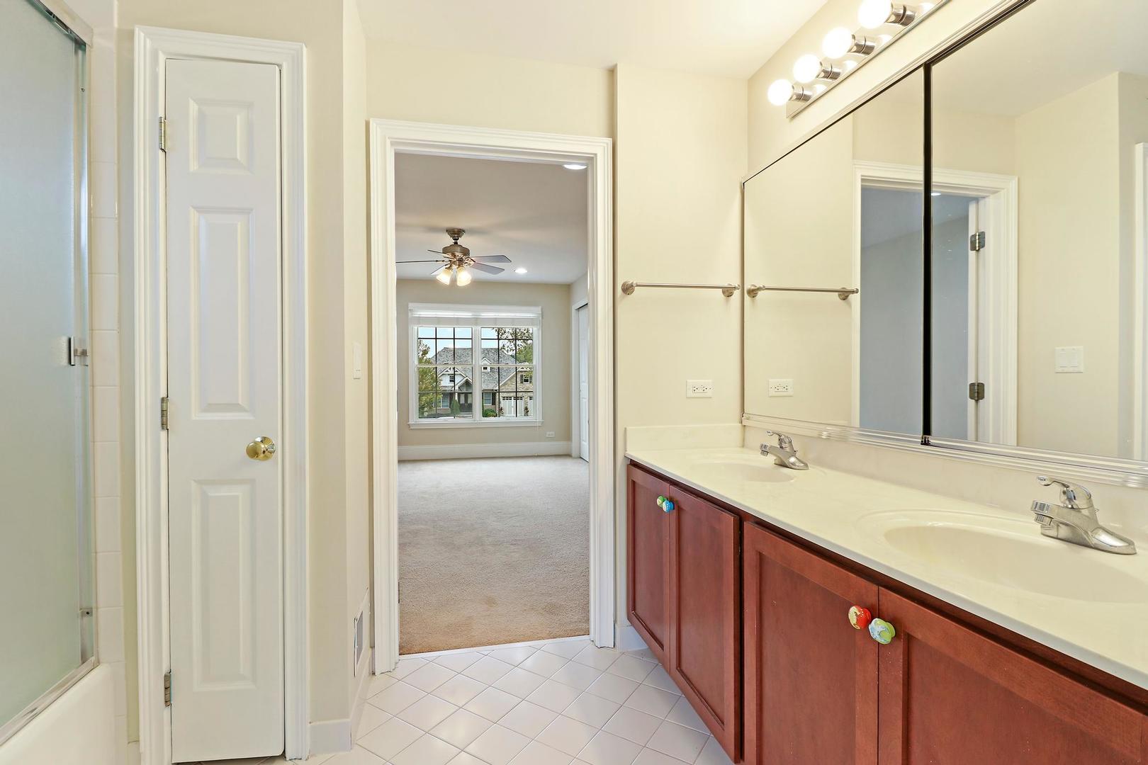 807 Poplar Court Inverness, IL 60010 - Photo 30 of 49 a bathroom with a double vanity sink a mirror and a shower