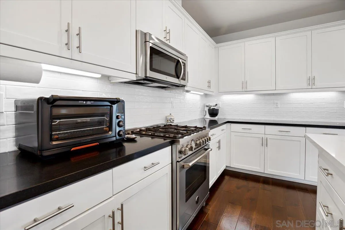 2123 Element Way Chula Vista, CA 91915 - Photo 11 of 42 a kitchen with granite countertop cabinets stainless steel appliances and wooden floor