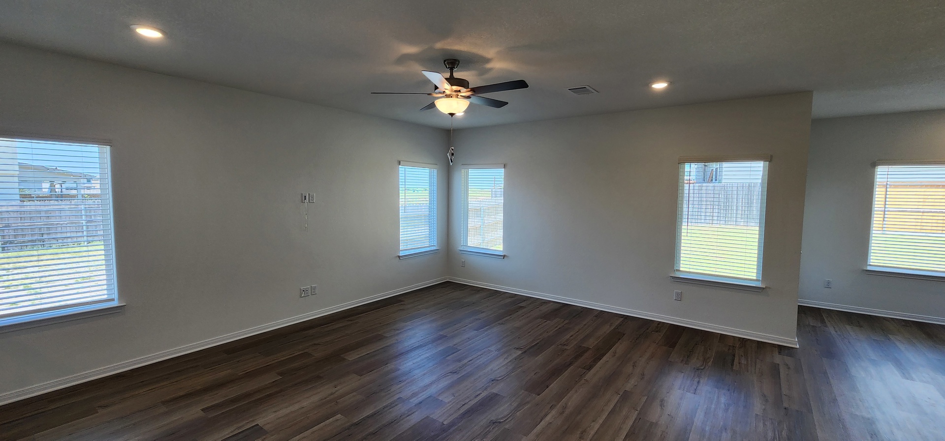 504 Yellow Ribbon Trail Jarrell, TX 76537 - Photo 2 of 8 A well-lit living area features rich hardwood flooring and a contemporary ceiling fan with integrated lighting.