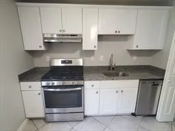 a kitchen with granite countertop white cabinets and stainless steel appliances