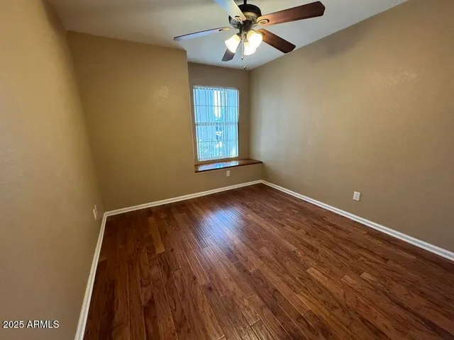 an empty room with wooden floor and closet area