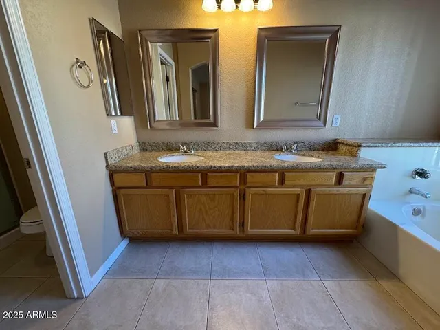 a bathroom with a granite countertop sink and a bathtub