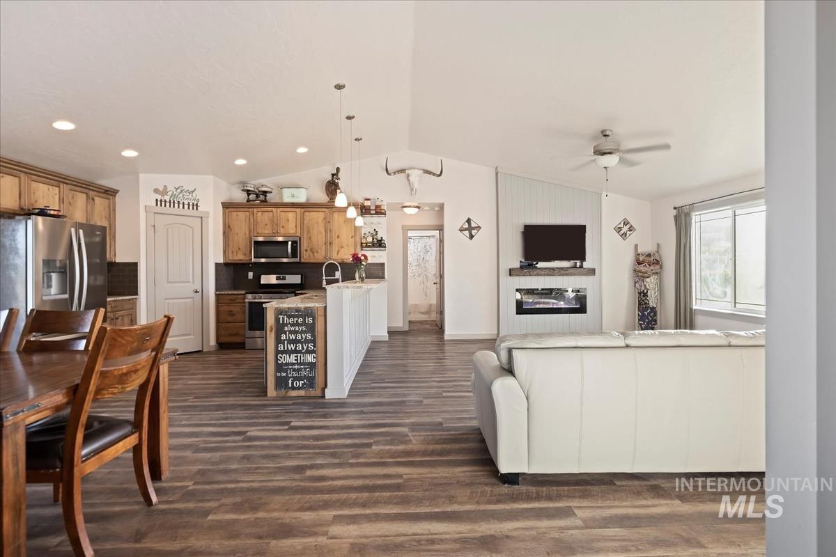 17571 Goodson Road Caldwell, ID 83607 - Photo 9 of 36 Living room featuring lofted ceiling, dark wood-style flooring, and a ceiling fan