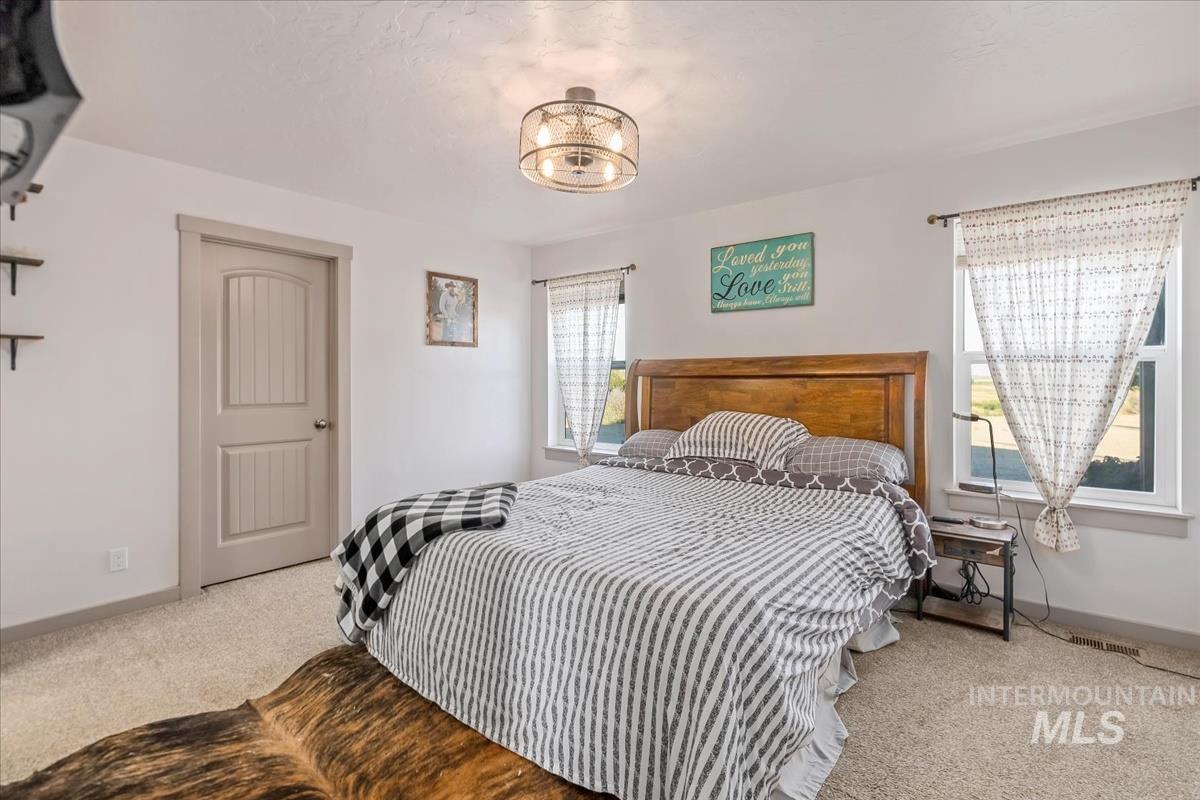 17571 Goodson Road Caldwell, ID 83607 - Photo 10 of 36 Bedroom featuring light colored carpet and baseboards